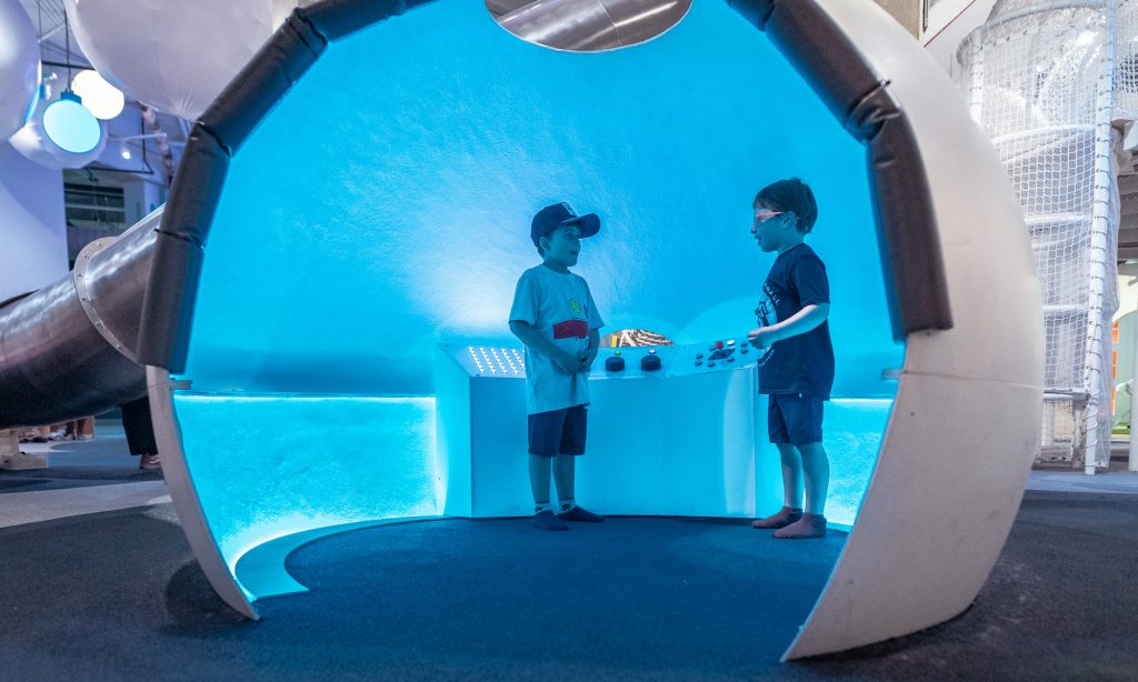 Two boys playing in the light pod in the Dream Machine exhibit