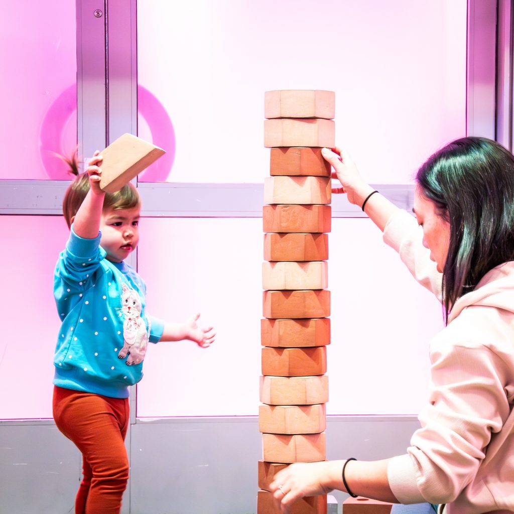 Young child stacking blocks in the Art + Tech exhibit.