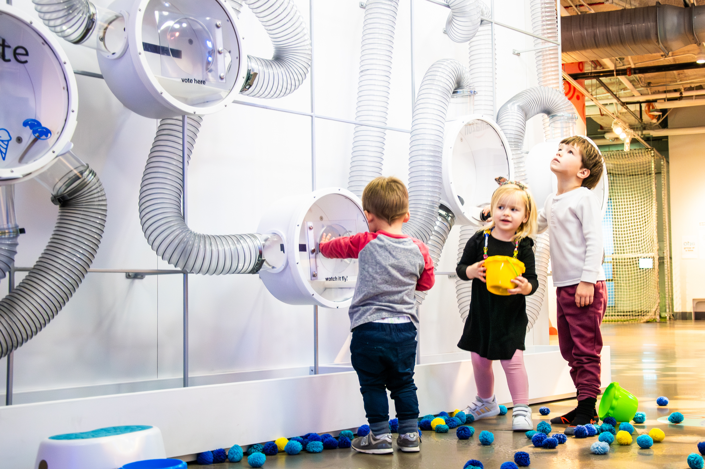 Children playing at the Pom Pom Poll experience in the Data Science Alley exhibit